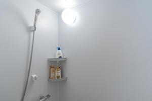 baño con ducha y estante con productos en kinyo inn 2 101, en Osaka