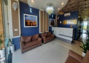 a lobby with two brown couches and a blue wall at Hotel Imperial in Dabok