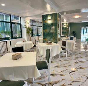 a dining room with white tables and chairs at Hotel Green House in Craiova