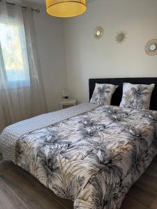 a bedroom with a bed with a comforter and a window at Villa Maeva Florensac in Florensac +29 photos