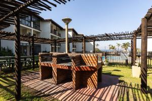a wooden pergola with a table in a yard at Topanga Beach Apartment in Margate