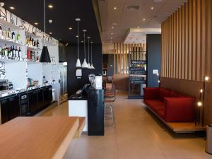 a restaurant with a bar and a red couch at Hotel Ibis Tatui in Tatuí