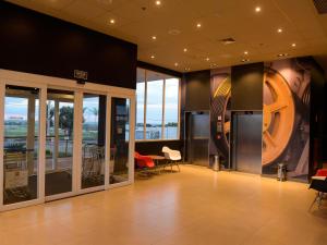 a lobby with tables and chairs in a building at Hotel Ibis Tatui in Tatuí +62 photos