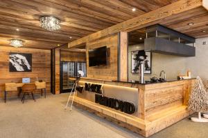 Una habitación con paredes de madera y un mostrador con un televisor. en Black Diamond - Chalet Bansky, en Les Brévières