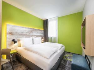 a bedroom with a bed and a green wall at ibis Styles Stuttgart Vaihingen in Stuttgart +70 photos