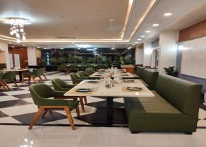 a dining room with a long table and green chairs at Hotel Imperial in Dabok