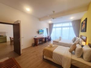 a hotel room with two beds and a desk at The Dorwin Heights in Kandy