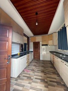 a large kitchen with wooden ceilings and a wooden floor at House For Rent In Rusororo fully furnished in Kigali