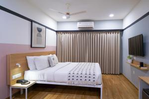 a bedroom with a bed and a television in it at Olive Hotel Indiranagar 100Ft Road by Embassy Group in Bengaluru