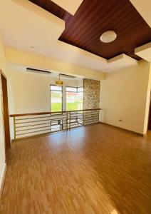 an empty room with a wooden floor and a ceiling at House For Rent In Rusororo fully furnished in Kigali