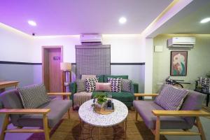 a living room with a couch and chairs and a table at Olive Hotel Indiranagar 100Ft Road by Embassy Group in Bengaluru