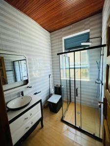 a bathroom with a glass shower and a sink at House For Rent In Rusororo fully furnished in Kigali