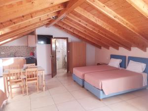 a bedroom with a bed and a table and a kitchen at George's Studios in Ermones