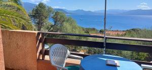 a table and chairs on a balcony with a view of the water at Bord de mer in Serra-di-Ferro