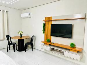 a living room with a television and a table at Pousada sousa Residencial Qrt 3 in Sousa
