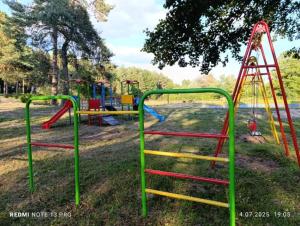 a park with a playground with a slide and a swing at Domek Chatka Czubatka in Bocheniec