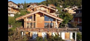 Cette grande maison en bois dispose d'un balcon. dans l'établissement Chalet Rosablanche, à Veysonnaz
