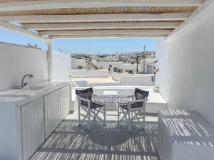 a patio with a table and chairs on a balcony at Brunella Paros in Naousa