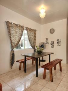 une salle à manger avec une table, des bancs et une fenêtre dans l'établissement Casa de Lucas, à Moalboal 30 autres photos