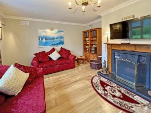 a living room with a red couch and a fireplace at 3 Bed in Glenbeigh oc-ii04686 in Glanbeny Bridge