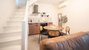 a living room with a table and chairs and a kitchen at La Loulove - Nid cosy & design au cœur de Lauzerte in Lauzerte