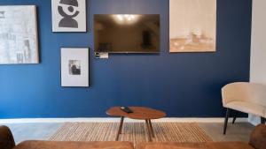 a living room with a blue wall and a table at La Loulove - Nid cosy & design au cœur de Lauzerte in Lauzerte