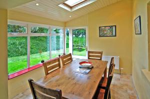 Un comedor con mesa y sillas de madera. en 4 Bed in Portmagee oc-i164, en Lateeve