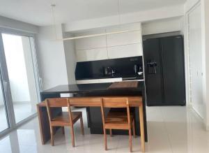 アテネにあるAether Loft in Marousi with Shared Poolのキッチン(テーブル、椅子2脚、黒い冷蔵庫付)