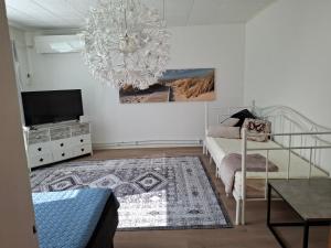 a bedroom with a chandelier and a bed and a television at Oulaisten mökkeröinen in Oulainen
