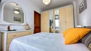 Un dormitorio con una cama y un espejo grande. en Apartamento Terraza Los Realejos, en Los Realejos