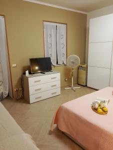 a bedroom with a bed and a dresser with a television at Casa Domenico in Messina +25 photos