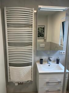 a white bathroom with a sink and a mirror at Helles & modernes Apartment mit privater Terrasse in Schwäbisch Hall +5 photos