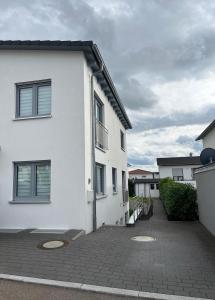 a white apartment building with a brick driveway at Helles & modernes Apartment mit privater Terrasse in Schwäbisch Hall