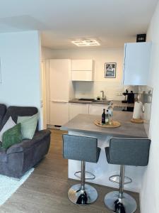 a kitchen and living room with a couch and a table at Modernes Apartment mit großer Terrasse & Parkplatz in Schwäbisch Hall +5 photos