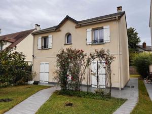 ein Haus mit einem Tor davor in der Unterkunft Maison Familiale au coeur d'aulnay sud, proche gare, aéroport CDG, Parc des expositions in Aulnay-sous-Bois