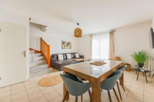 a living room with a wooden table and chairs at Family Elegance - Comfort & Garden in Cormeilles-en-Parisis