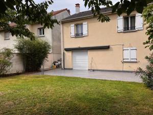 ein Haus mit Garagentor und Hof in der Unterkunft Maison Familiale au coeur d'aulnay sud, proche gare, aéroport CDG, Parc des expositions in Aulnay-sous-Bois + 3 Fotos