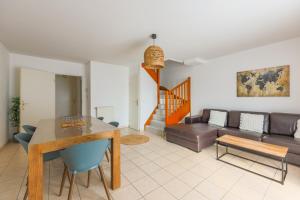 a living room with a table and a couch at Family Elegance - Comfort & Garden in Cormeilles-en-Parisis