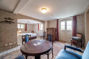 a living room with a table and a bed at Gutshaus Lietzow in Nauen