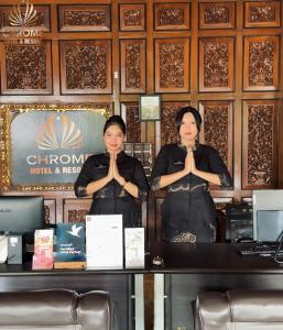 two women sitting at a table with their hands in their mouths at chrome hotel & resort solo in Tjolomadu +145 photos
