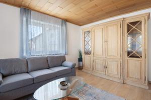 Vohburg an der DonauにあるFerienhaus Donauliebeのソファとガラスのテーブルのあるリビングルーム