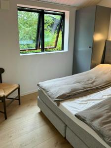 a bedroom with two beds and a window at Modern Family Home Near Marielyst Beach in Marielyst