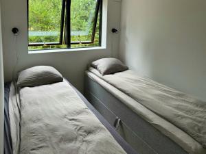 two beds in a room with a window at Modern Family Home Near Marielyst Beach in Marielyst
