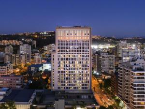 a tall white building in a city at night at Novotel Vina del Mar in Viña del Mar