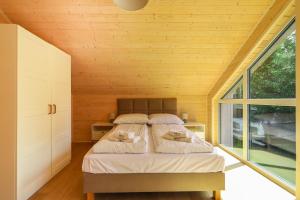 ミエルノにあるMi Casa Holidays Domki całoroczneのベッドと大きな窓のある寝室