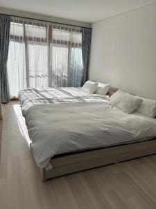 a large bed in a bedroom with a large window at 宿中村屋 in Aomori