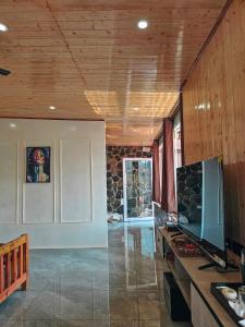a living room with a tv and a table with a television at Panoramic Jacuzzi Suite with huge Balcony & Swing in Mussoorie