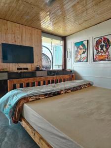 a large bed in a room with a television at Panoramic Jacuzzi Suite with huge Balcony & Swing in Mussoorie