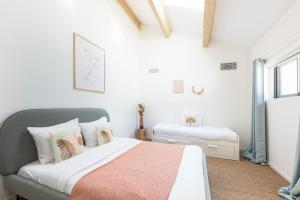 a white bedroom with a bed and a window at La Bastide du Père Mathieu Jacuzzi couvert et Piscine in Suze-la-Rousse