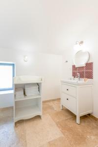 a white bathroom with a sink and a mirror at La Bastide du Père Mathieu Jacuzzi couvert et Piscine in Suze-la-Rousse +42 photos